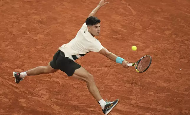 Spain's Carlos Alcaraz returns the ball to Hungary's Fabian Maroszan during their second round match of the French Tennis Open, at the Roland-Garros stadium, in Paris, Wednesday, May 28, 2025. (AP Photo/Christophe Ena)