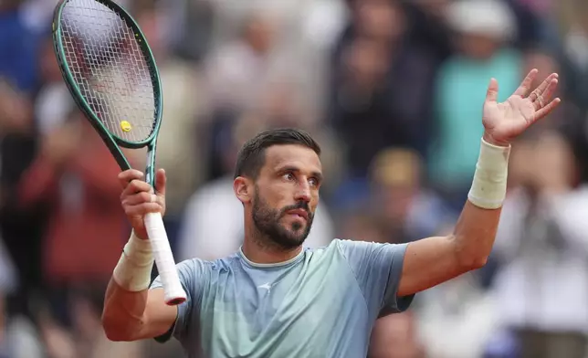 Bosnia and Herzegovina's Damir Dzumhur celebrates after beating France's Giovanni Mpetshi Perricard during their second round match of the French Tennis Open, at the Roland-Garros stadium, in Paris, Wednesday, May 28, 2025. (AP Photo/Lindsey Wasson)