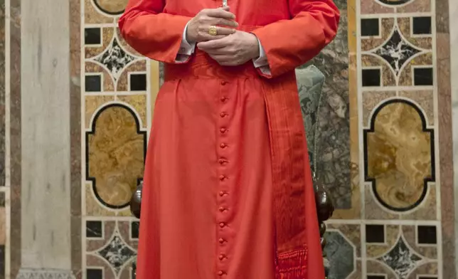 FILE - Newly-elected Cardinal James Michael Harvey from the U.S. poses for photographers prior to meeting relatives and friends after he was elevated to cardinal by Pope Benedict XVI, at the Vatican during a consistory, Nov. 24, 2012. (AP Photo/Andrew Medichini, File)