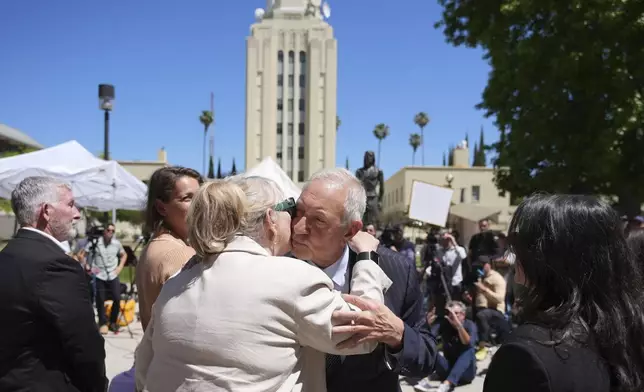 Attorney Mark Geragos, a lawyer for Erik and Lyle Menendez, center right, kisses a family member of the brothers after a hearing in their case at the courthouse Friday, May 9, 2025, in Los Angeles. (AP Photo/Jae C. Hong)