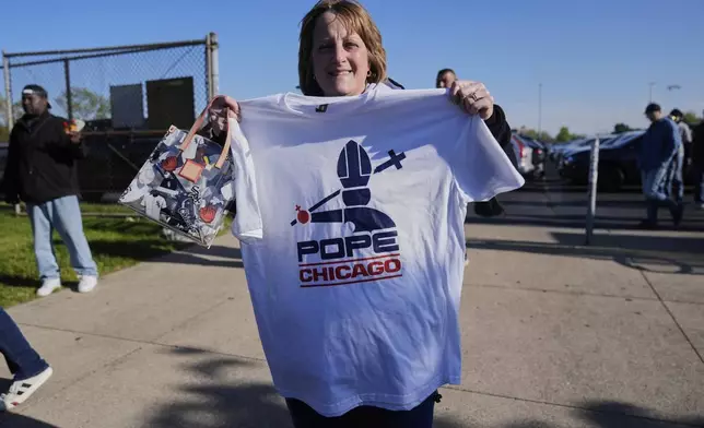 Sue Rosinski holds a Pope Leo XIV-themed shirt she bought outside Rate Field before a baseball game between the Chicago White Sox and Miami Marlins, Saturday, May 10, 2025, in Chicago. (AP Photo/Erin Hooley)