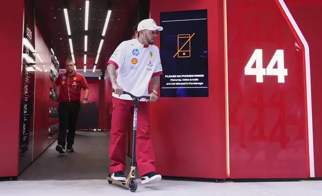 Ferrari driver Lewis Hamilton, of Britain, rides a scooter as he leaves the Ferrari garage ahead of the Formula One Miami Grand Prix auto race, Thursday, May 1, 2025, in Miami Gardens, Fla. (AP Photo/Rebecca Blackwell)