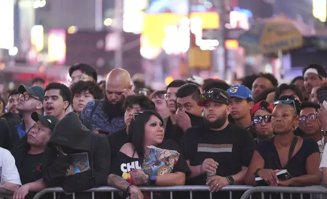 People gather in Times Square to watch a boxing match Friday, May 2, 2025, in New York. (AP Photo/Frank Franklin II)