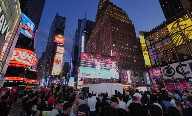 People gather in Times Square to watch a boxing match Friday, May 2, 2025, in New York. (AP Photo/Frank Franklin II)
