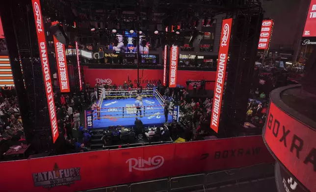 Fans watch Teofimo Lopez and Arnold Barboza Jr. fight during a super lightweight boxing match in Times Square Friday, May 2, 2025, in New York. (AP Photo/Frank Franklin II)