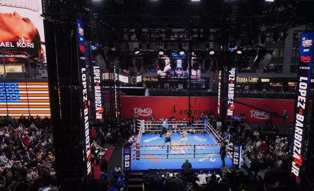 People gather in Times Square to watch a boxing match Friday, May 2, 2025, in New York. (AP Photo/Frank Franklin II)