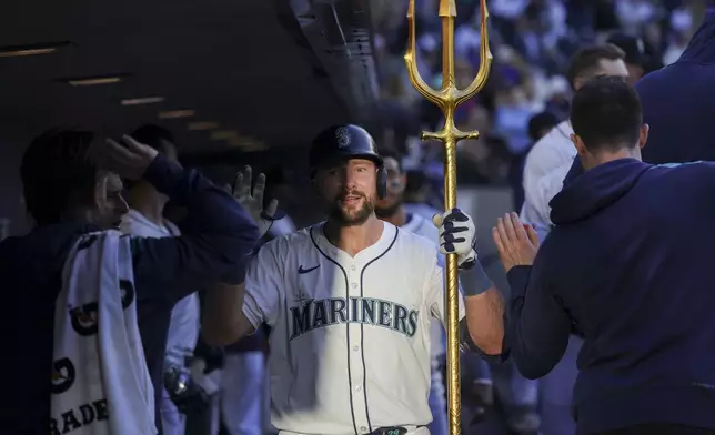Seattle Mariners' Cal Raleigh celebrates in the dugout after hitting a solo home run during the fifth inning of a baseball game against the Washington Nationals, Tuesday, May 27, 2025, in Seattle. (AP Photo/Ryan Sun)