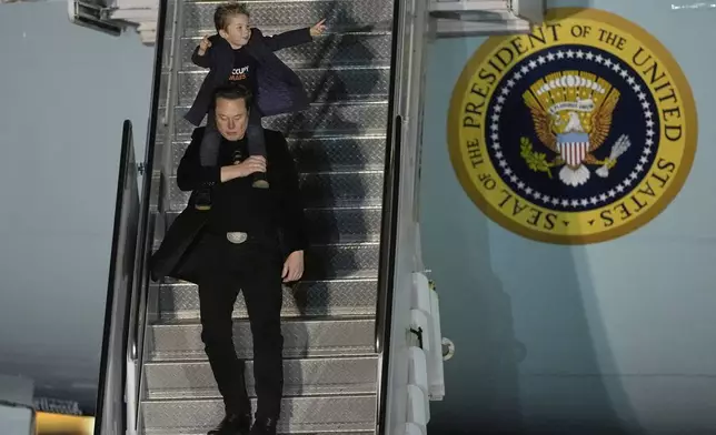FILE - Elon Musk carries his son X Æ A-Xii as they arrives on Air Force One with President Donald Trump, not pictured, at Miami International Airport, April 12, 2025, in Miami, Fla. (AP Photo/Manuel Balce Ceneta, File)
