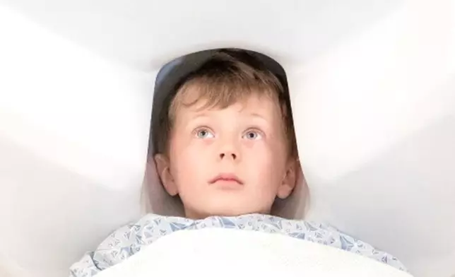 Five-year-old child in an adult sized MEG helmet.