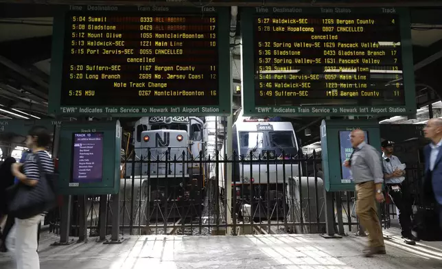 FILe - People head to trains at the New Jersey Transit station in Hoboken, N.J., on Tuesday, Aug. 7, 2018. (AP Photo/David Boe, File)