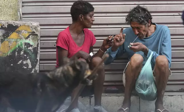 A drug addict smokes crack cocaine in a downtown area popularly known as "Crackland" in Sao Paulo, Tuesday, May 20, 2025. (AP Photo/Andre Penner)