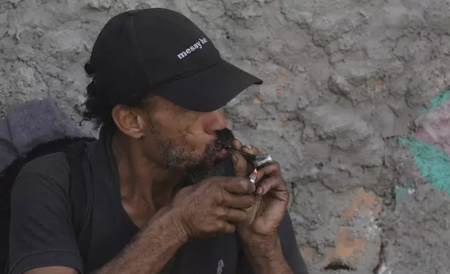 A drug addict smokes crack cocaine in a downtown area popularly known as "Crackland" in Sao Paulo, Tuesday, May 20, 2025. (AP Photo/Andre Penner)