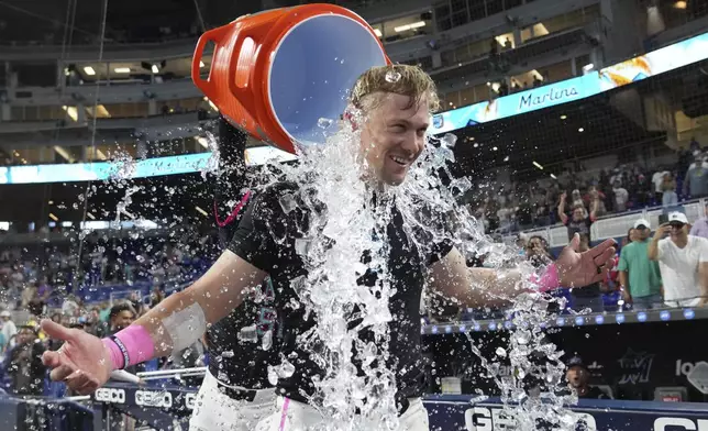 Miami Marlins' Kyle Stowers is doused with ice after hitting a walk-off grand slam in the ninth inning of a baseball game against the Oakland Athletics, Saturday, May 3, 2025, in Miami. (AP Photo/Lynne Sladky)