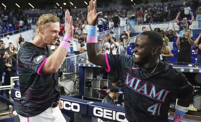 Miami Marlins' Kyle Stowers, left, high fives Ronny Simon (41) after hitting a walk-off grand slam during the ninth inning of a baseball game against the Oakland Athletics, Saturday, May 3, 2025, in Miami. (AP Photo/Lynne Sladky)