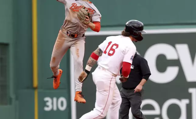 Baltimore Orioles shortstop Gunnar Henderson, left, throws to first base after tagging out Boston Red Sox's Jarren Duran (16) at second base on a double play during the fifth inning of a baseball game Sunday, May 25, 2025, in Boston. (AP Photo/Mark Stockwell)