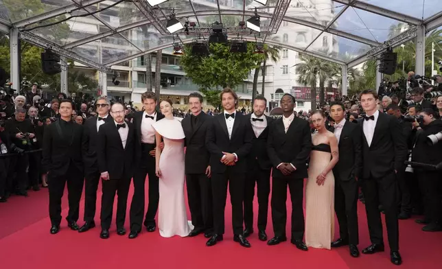 Clifton Collins Jr., from left, Joaquin Phoenix, director Ari Aster, Austin Butler, Emma Stone, Pedro Pascal, Luke Grimes, producer Lars Knudsen, Micheal Ward, Amelie Hoeferle, Matt Gomez Hidaka and Cameron Mann pose for photographers upon arrival at the premiere of the film 'Eddington' at the 78th international film festival, Cannes, southern France, Friday, May 16, 2025. (AP Photo/Natacha Pisarenko)