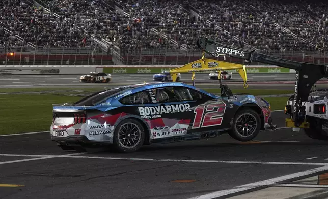 Ryan Blaney (12) is towed after being involved in a wreck during a NASCAR Cup Series auto race at Charlotte Motor Speedway, Sunday, May 25, 2025, in Concord, N.C. (AP Photo/Matt Kelley)