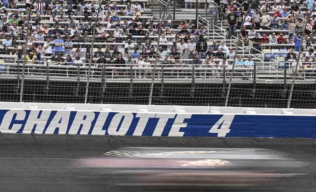 Fans look on as drivers compete through Turn 4 during a NASCAR Cup Series auto race at Charlotte Motor Speedway, Sunday, May 25, 2025, in Concord, N.C. (AP Photo/Matt Kelley)
