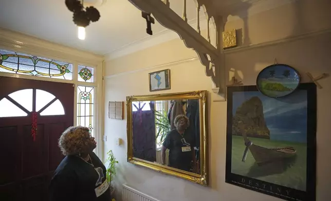 Chagossian Bernadette Dugasse looks at a Chagos Islands map during an interview with The Associated Press, at her home in London, Tuesday, March 25, 2025. (AP Photo/Kin Cheung)