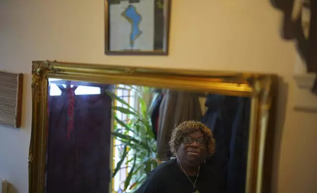 Chagossian Bernadette Dugasse looks at a Chagos Islands map during an interview with The Associated Press, at her home in London, Tuesday, March 25, 2025. (AP Photo/Kin Cheung)