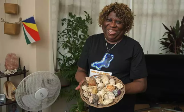 Chagossian Bernadette Dugasse shows sea shells from the Chagos Islands during an interview with The Associated Press, at her home in London, Tuesday, March 25, 2025. (AP Photo/Kin Cheung)