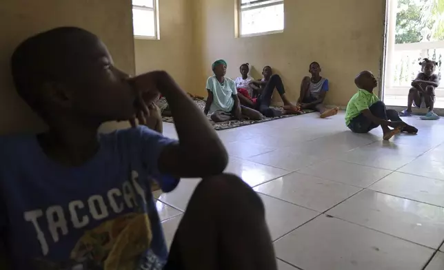 Children watch a movie after receiving their medication at the Caring for Haitian Orphans with AIDS orphanage, in Balan, Plaine-du-Nord, Haiti, Wednesday, May 21, 2025. (AP Photo/Patrice Noel)
