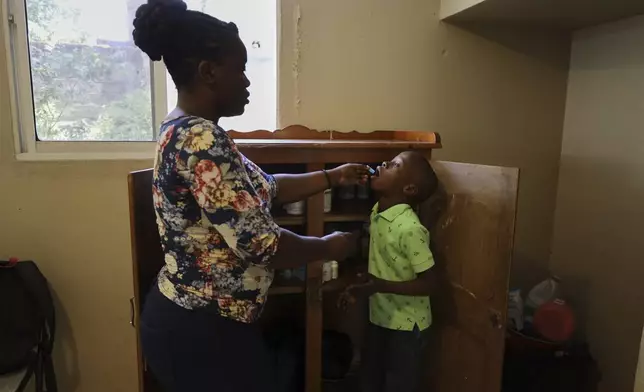 Nurse Préjuste Mexandra administers medicine to a child at the Caring for Haitian Orphans with AIDS orphanage, in Balan, Plaine-du-Nord, Haiti, Wednesday, May 21, 2025. (AP Photo/Patrice Noel)