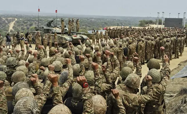 In this photo released by the Inter Services Public Relations, Pakistan's Army Chief Asim Munir, second left standing on tank, chant 'long live Pakistan' slogans with soldiers during his visit to witness military exercises, in Tilla Field Firing Range in the Jhelum district, Pakistan, Thursday, May 1, 2025. (Inter Services Public Relations via AP)