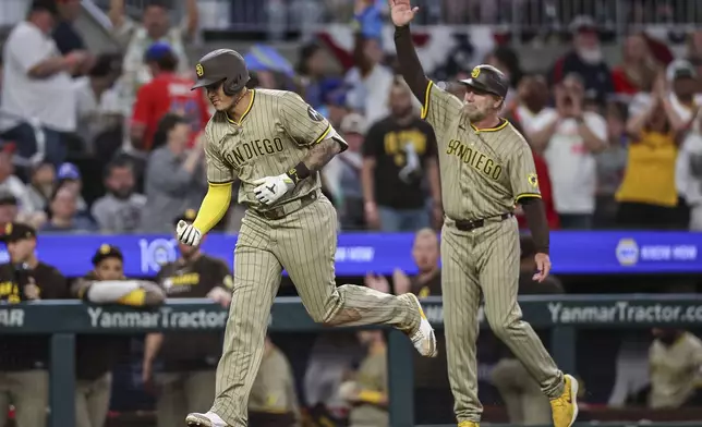 San Diego Padres' Manny Machado, left, rounds third base after hitting a home run in the ninth inning of a baseball game against the Atlanta Braves, Friday, May 23, 2025, in Atlanta. (AP Photo/Colin Hubbard)