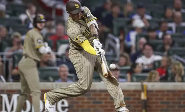 San Diego Padres' Manny Machado hits a home run in the ninth inning of a baseball game against the Atlanta Braves, Friday, May 23, 2025, in Atlanta. (AP Photo/Colin Hubbard)
