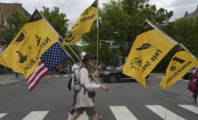 Ross Brubeck and other members of the Quaker March to Washington cross a street on their way to a meeting house in Princeton, N.J., on Wednesday May 7, 2025. (AP Photo/Luis Andres Henao)
