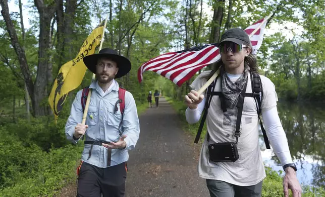 Max Goodman, left, and Ross Brubeck walk on a trail near Princeton, N.J., as part of a Quaker march from New York City to Washington D.C. to protest President Donald Trump's crackdown on immigrants on Wednesday May 7, 2025. (AP Photo/Luis Andres Henao)