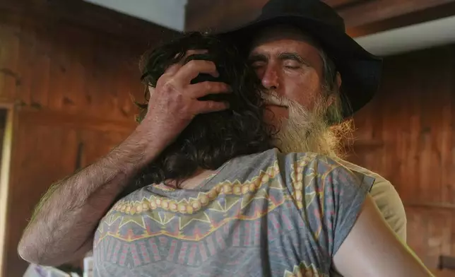 Stuart Sydenstricker, right, and Jules Wing Vasquez hug after completing a portion of the Quaker March to Washington at the Quaker Meeting House in Princeton, N.J. (AP Photo/Luis Andres Henao)