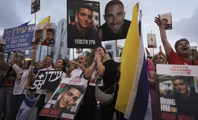 FILE - People watch a live broadcast of Israeli-American soldier Edan Alexander's release from Hamas captivity at a plaza known as the hostages square in Tel Aviv, May 12, 2025. (AP Photo/Oded Balilty, File)