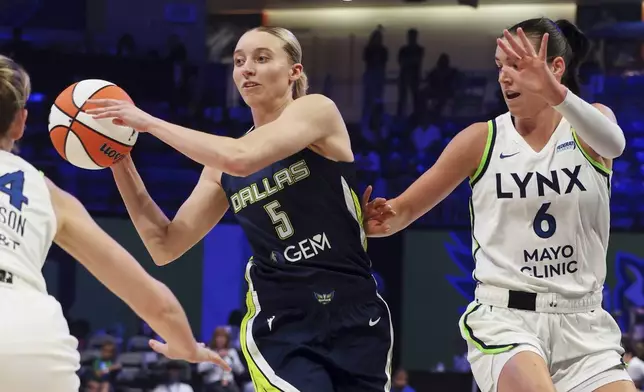 Dallas Wings guard Paige Bueckers (5) makes a pass under pressure from Minnesota Lynx's Karlie Samuelson, left, and Bridget Carleton (6) in the first half of a WNBA basketball game Friday, May 16, 2025, in Arlington, Texas. (AP Photo/Richard Rodriguez)
