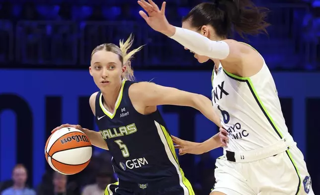 Dallas Wings' Paige Bueckers (5) works against Minnesota Lynx forward Bridget Carleton, right, in the first half of a WNBA basketball game Friday, May 16, 2025, in Arlington, Texas. (AP Photo/Richard Rodriguez)