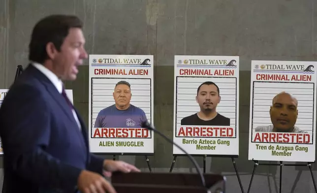 Posters of alleged criminals who officials said were arrested in a recent immigration enforcement operation are displayed as Gov. Ron DeSantis speaks during a press conference at the South Florida office of U.S. Immigration and Customs Enforcement and Enforcement and Removal Operations, Thursday, May 1, 2025, in Miramar, Fla. (AP Photo/Rebecca Blackwell)