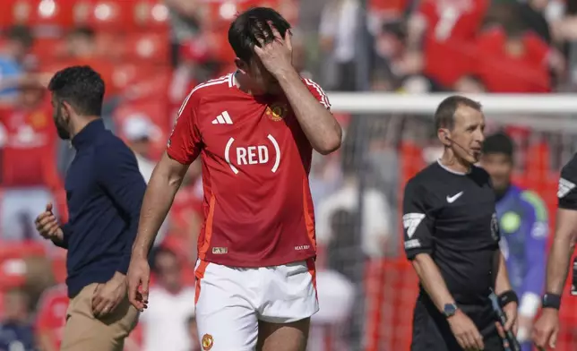 Manchester United's Harry Maguire walks on the pitch in dejection at the end of the English Premier League soccer match between Manchester United and West Ham at Old Trafford stadium in Manchester, England, Sunday, May 11, 2025. (AP Photo/Ian Hodgson)
