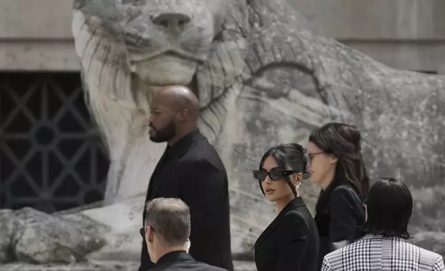 Kim Kardashian, center, arrives to testify regarding a robbery of millions of dollars in jewels from her Paris hotel room in 2016, in Paris, Tuesday, May 13, 2025. (AP Photo/Aurelien Morissard)