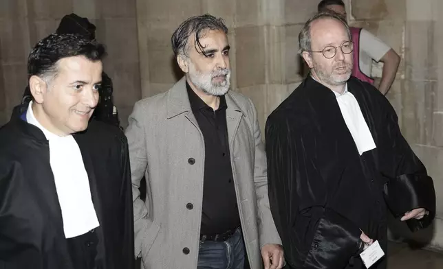 Abderrahmane Ouatiki, center, who was working as a hotel receptionist, is flanked by his lawyers Mohand Ouidja, left, and Henri De Beauregard during the trial of the 2016 armed robbery of Kim Kardashian, at the palace of justice, Tuesday, May 13, 2025 in Paris. (AP Photo/Aurelien Morissard)