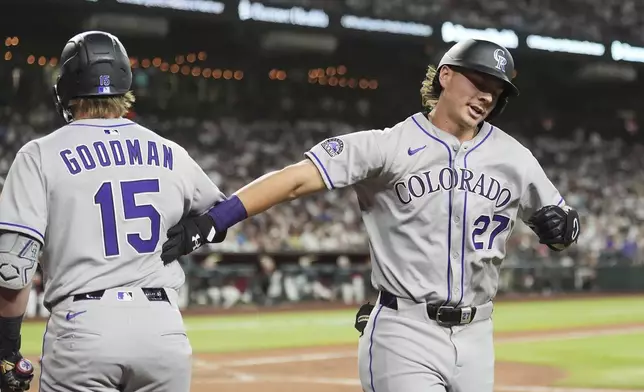 Colorado Rockies' Jordan Beck (27) celebrates his two-run home run against the Arizona Diamondbacks with Rockies' Hunter Goodman (15) during the seventh inning of a baseball game Saturday, May 17, 2025, in Phoenix. (AP Photo/Ross D. Franklin)