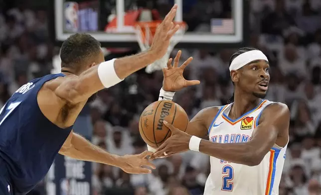 Oklahoma City Thunder guard Shai Gilgeous-Alexander (2) looses controls of the ball while defended by Minnesota Timberwolves center Rudy Gobert (27) during the first half of Game 3 of the Western Conference finals of the NBA basketball playoffs, Saturday, May 24, 2025, in Minneapolis. (AP Photo/Abbie Parr)