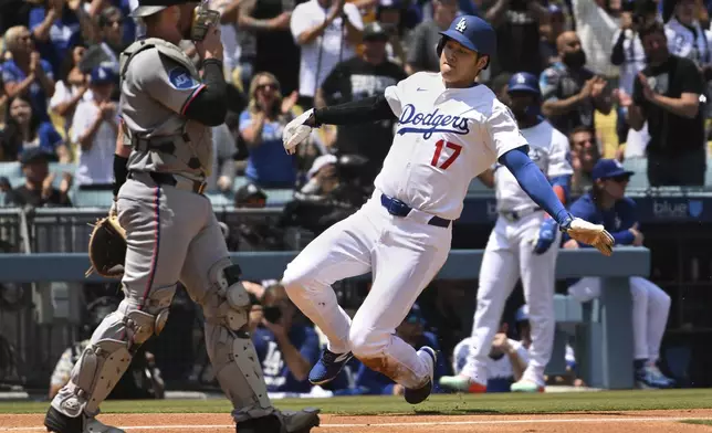 Los Angeles Dodgers's Shohei Ohtani (17) slides home to score a run in front of Miami Marlins catcher Liam Hicks (34) during the third inning of a baseball game Wednesday, April 30, 2025, in Los Angeles. (AP Photo/Wally Skalij)
