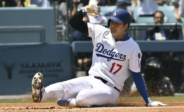 Los Angeles Dodgers' Shohei Ohtani (17) slides home to sore a run against the Miami Marlins during the third inning of a baseball game Wednesday, April 30, 2025, in Los Angeles. (AP Photo/Wally Skalij)