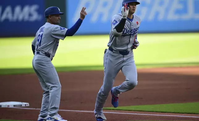 Los Angeles Dodgers' Shohei Ohtani, right, is congratulated by third base coach Dino Ebel, left, after hitting a solo home run off Cleveland Guardians starting pitcher Gavin Williams during the first inning of a baseball game, Monday, May 26, 2025, in Cleveland. (AP Photo/David Dermer)