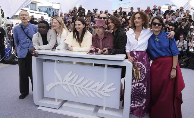 Jury president Juliette Binoche, fourth from left, and jury members Hong Sang-soo, from left, Dieudo Hamadi, Alba Rohrwacher, Jeremy Strong, Halle Berry, Leila Slimani and Payal Kapadia pose for photographers at the jury photo call at the 78th international film festival, Cannes, southern France, Tuesday, May 13, 2025. (AP Photo/Natacha Pisarenko)