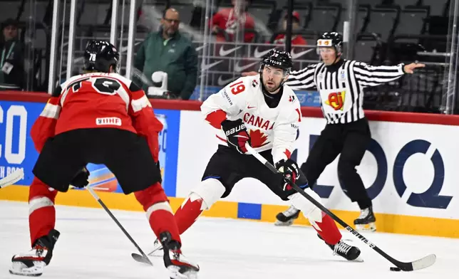 Canada's Adam Fantilli, center, plays the puck during the IIHF Ice Hockey World Championship group A match between Canada and Austria in Stockholm, Sweden, Thursday, May 15, 2025. (Anders Wiklund/TT News Agency via AP)