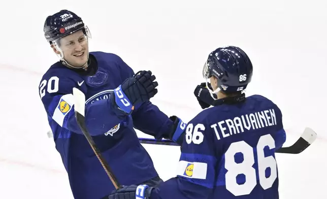 Finland's Finland's Eeli Tolvanen, left, celebrate after scoring his side's seventh goal during the IIHF Ice Hockey World Championship group A match between Finland and Slovenia in Stockholm, Sweden, Thursday, May 15, 2025. (Anders Wiklund/TT News Agency via AP)