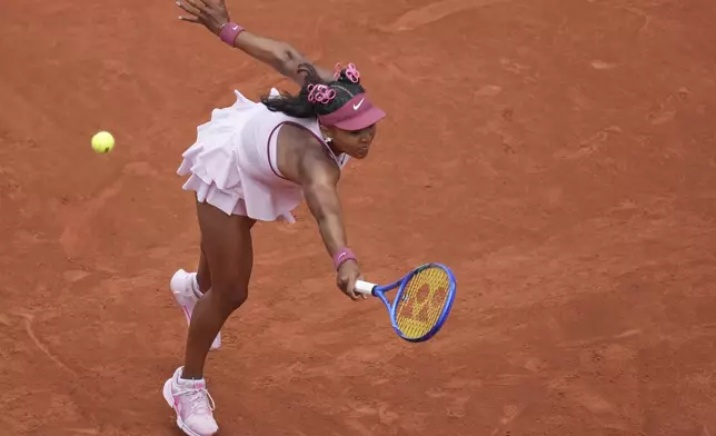 Japan's Naomi Osaka returns the ball to Spain's Paula Badosa during their first round match of the French Tennis Open, at the Roland-Garros stadium, in Paris, Monday, May 26, 2025. (AP Photo/Christophe Ena)