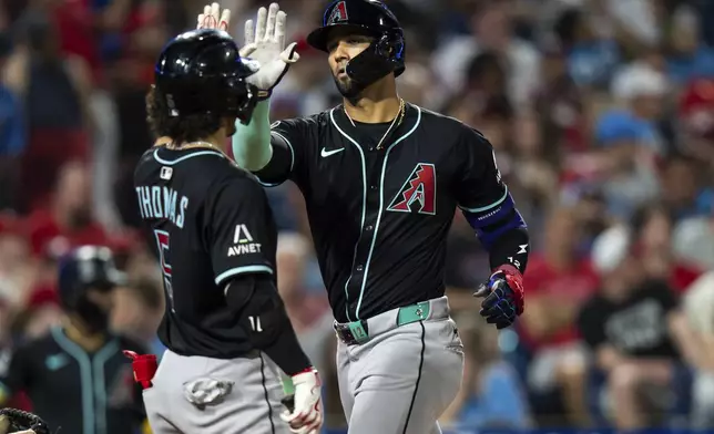 Arizona Diamondbacks' Lourdes Gurriel, right, celebrates after his two-run home run with Alek Thomas, left, during the seventh inning of a baseball game against the Philadelphia Phillies, Saturday, May 3, 2025, in Philadelphia. (AP Photo/Chris Szagola)